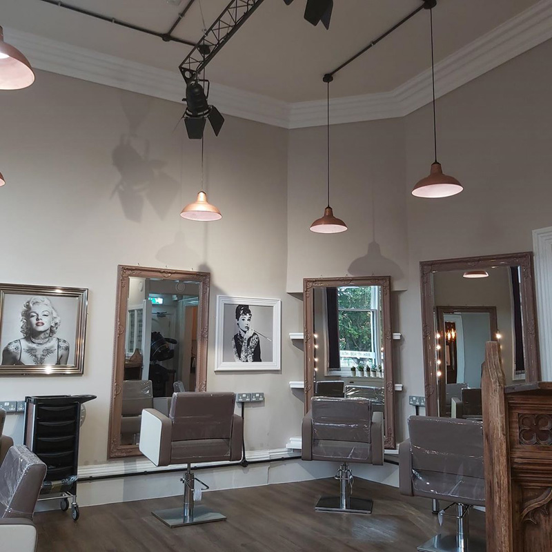 hair salon interior with wall art and copper lamps